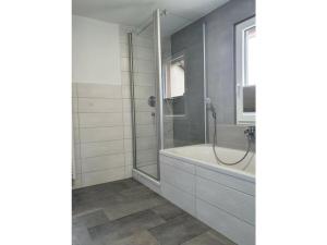 uma casa de banho com um chuveiro e uma banheira em 1 Fuchskreuzhof Modern retreat em Simmersfeld