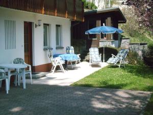 eine Terrasse mit Stühlen, einem Tisch und einem Sonnenschirm in der Unterkunft Haus Becker-Schmidt, St Blasien in St. Blasien