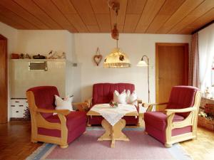 sala de estar con sillas rojas, mesa y mesa de comedor en Valley view in the Ferienhaus Schenk 