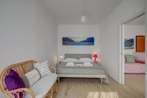 1 dormitorio con cama, sofá y espejo en Casa al Cor Apartments - Happy Rentals, en Nago-Torbole