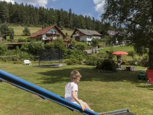 Un jeune garçon grimpe sur un toboggan bleu dans l'établissement Oberrain in the Ferienhaus Schenk, 