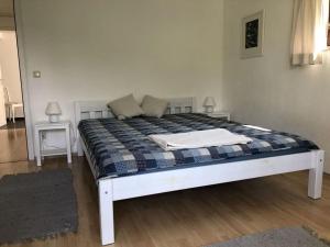 a white bed with a blue and white plaid blanket at Holiday apartment at Molopark in Murnau am Staffelsee