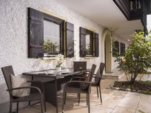 - une table à manger et des chaises sur la terrasse dans l'établissement Holiday apartment No 5 Bergschlössl, à Oberaudorf