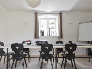 a meeting room with black chairs and a white table at Grassau washhouse in Grassau