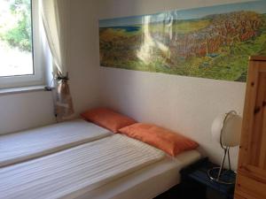 Ce lit se trouve dans un dortoir orné d'une peinture murale. dans l'établissement Gaienhofen Modern retreat, à Gaienhofen