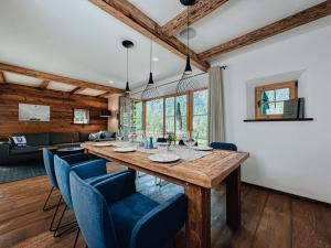 a dining room with a wooden table and blue chairs at Chalet Alpin Modern retreat in Bayrischzell