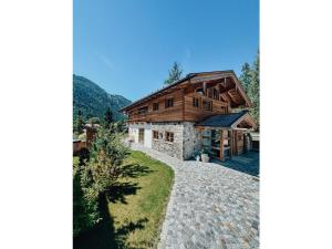 dom z kamienną ścieżką prowadzącą do niego w obiekcie Chalet Alpin Modern retreat w mieście Bayrischzell