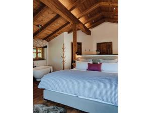Chalet Alpin Modern retreat في بايريشزيل: غرفة نوم بسرير ازرق وحوض استحمام