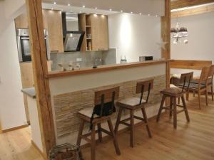 a kitchen with a bar with stools and a table at Alpenliebe Modern retreat in Reit im Winkl