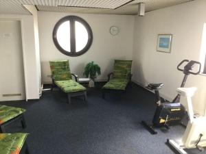 ein Wartezimmer mit Stühlen, einem Laufband und einem Fenster in der Unterkunft Holiday apartment WeserWeitblick in Bremerhaven