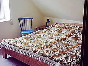 a bed in a room with a blue chair at at Bunge Heath Farm - formerly TUI Ferienhaus in Uelzen