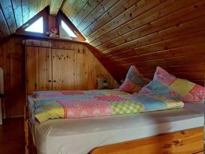 a bed in a room with a wooden ceiling at Eisenmann holiday farm in Gengenbach
