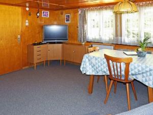 a dining room with a table and a television at Rappenloch Modern retreat in Eisenbach