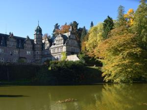 een groot kasteel aan de kant van een meer bij Villa Taubenberg in Rinteln