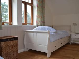 ein weißes Bett in einem Zimmer mit 2 Fenstern in der Unterkunft Villa Taubenberg in Rinteln