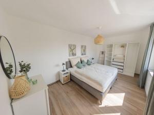 a white bedroom with a bed and a desk at Luxury apartment Bad Salzuflen in Bad Salzuflen