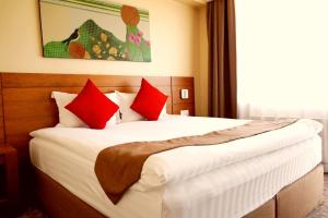 a bedroom with a large bed with red pillows at Red Rock Resort in Ulaanbaatar