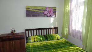 a bedroom with a bed with green and yellow sheets at Apartments Rokytka - Praha in Prague