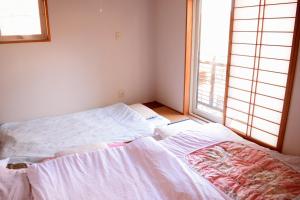 Postel nebo postele na pokoji v ubytování Sasamori House