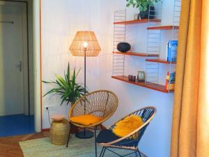 Habitación con 2 sillas, mesa y lámpara en Time travel, open-plan apartment en Merano