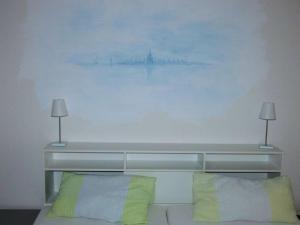 - un lit avec deux oreillers et un tableau mural dans l'établissement Exclusively in Konstanz Paradies, à Constance