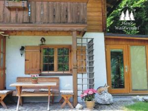 un chat assis sur un banc à l'extérieur d'un bâtiment dans l'établissement Waterval in het huis Boshoek, à Aschau im Chiemgau