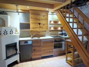 eine Küche mit Holzschränken und einer Treppe in der Unterkunft Waterval in het huis Boshoek in Aschau im Chiemgau