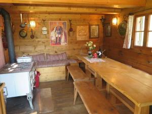 a kitchen with a table and a bench in a cabin at Waterval in het huis Boshoek in Aschau im Chiemgau