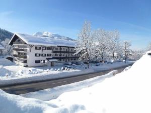 un bâtiment dans la neige avec des arbres enneigés dans l'établissement Bergglück Modern retreat, à Reit im Winkl