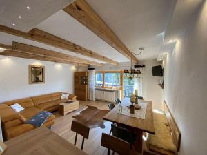 een woonkamer met een bank en een tafel bij Bergglück Modern retreat in Reit im Winkl