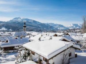 a snow covered roof of a building with a church at Bergglück Comfortable holiday residence in Reit im Winkl