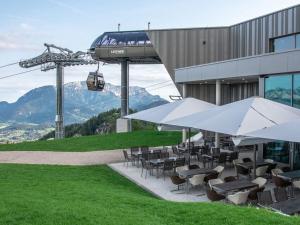 un restaurant avec des tables et des chaises ainsi qu'une remontée mécanique dans l'établissement Apartment Almrausch, à Berchtesgaden