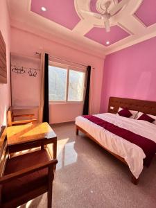 a bedroom with a bed and a purple ceiling at Hotel Shri S.K. & Restaurant, Uttarkashi in Nākuri