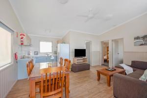 a kitchen and living room with a table and a couch at Reflections Tuncurry - Holiday Park in Tuncurry