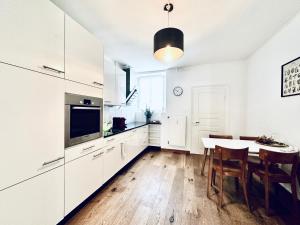 a kitchen with white cabinets and a table with chairs at Business Apartment in Derendingen in Derendingen