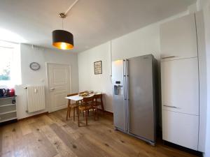 a kitchen with a table and a stainless steel refrigerator at Business Apartment in Derendingen in Derendingen