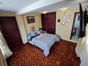 Dormitorio con cama con colcha a cuadros en MATRIMONIAL TURI centro de la ciudad, garaje, en Baños