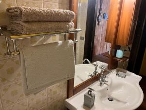 W łazience znajduje się umywalka i lustro. w obiekcie Appartamento Superior Condominio Orso Bianco, parquet, Wi-Fi w mieście Prati di Tivo