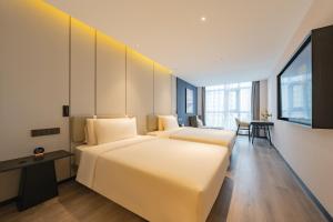 a hotel room with two beds and a table at Atour Hotel Beijing Guomao Tuanjie Lake in Beijing