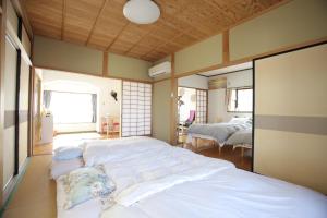 松江市一棟貸し別荘つる的一间带两张床的卧室和一间带两扇窗户的房间