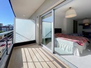 a bedroom with a balcony with a bed and a glass door at Caballito Retreat Pool and Balcony 6K in Buenos Aires