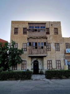 ein altes Backsteingebäude mit einer Tür vorne in der Unterkunft El Quseir Hotel in Al-Qusair