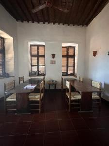 a dining room with two tables and chairs and windows at El Quseir Hotel in Quseir