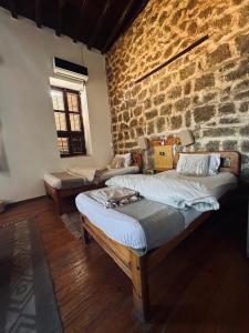 um quarto com duas camas e uma parede de tijolos em El Quseir Hotel em El Quseir
