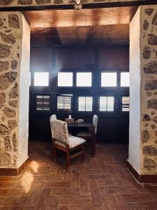 a dining room with a table and chairs and windows at El Quseir Hotel in Quseir