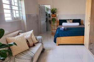 uma sala de estar com uma cama e um sofá em Guesthouse room with Kitchenette & Ensuite Bathroom em Ấp Mỹ Hải