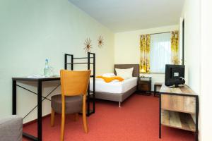 a bedroom with a bed and a desk and a bed at Wanderhotel Sonnebergbaude in Waltersdorf