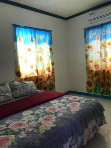 1 dormitorio con 1 cama y 2 ventanas con flores en Joy O Hoy Beach House, en Santander