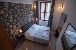 een kleine slaapkamer met een bed en een bloemenmuur bij Hotel Francesco in Pisa