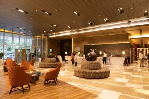 a lobby with chairs and tables in a building at Holiday Inn New Delhi International Airport, an IHG Hotel in New Delhi